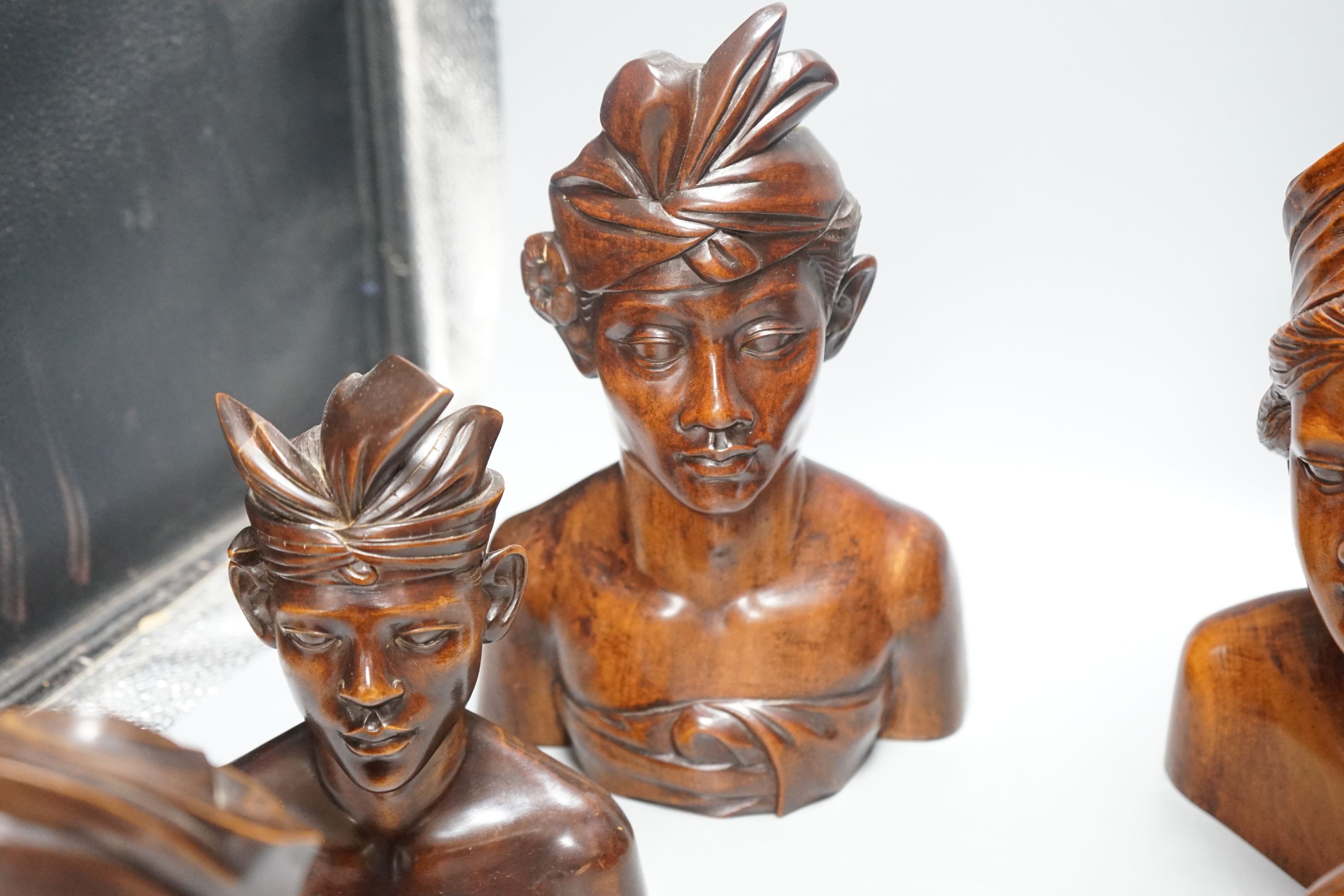 A pair of carved bird bookends ,and two pairs of carved Balinese busts